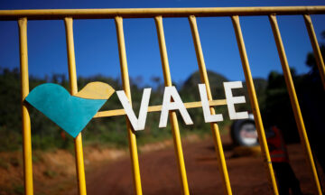 Imagem mostra uma placa da Vale em cenário de dejetos no interior de Minas Gerais.