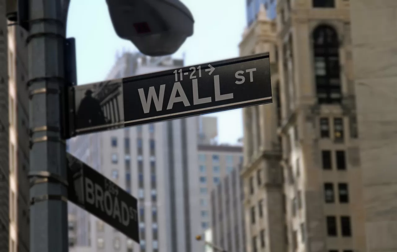 Placa de Wall Street mostrando prédios ao fundo Empresas dos EUA divulgaram seus balanços nesta quinta-feira.
