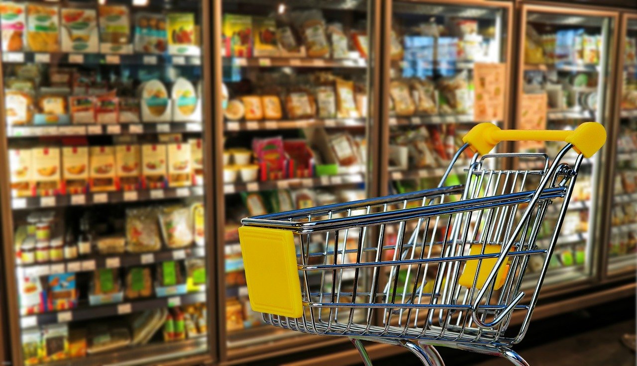 Confiança do consumidor cai 3,1 pontos em maio de 2022. Imgem mostra gôndola de supermercado e carrinho vazio à frente