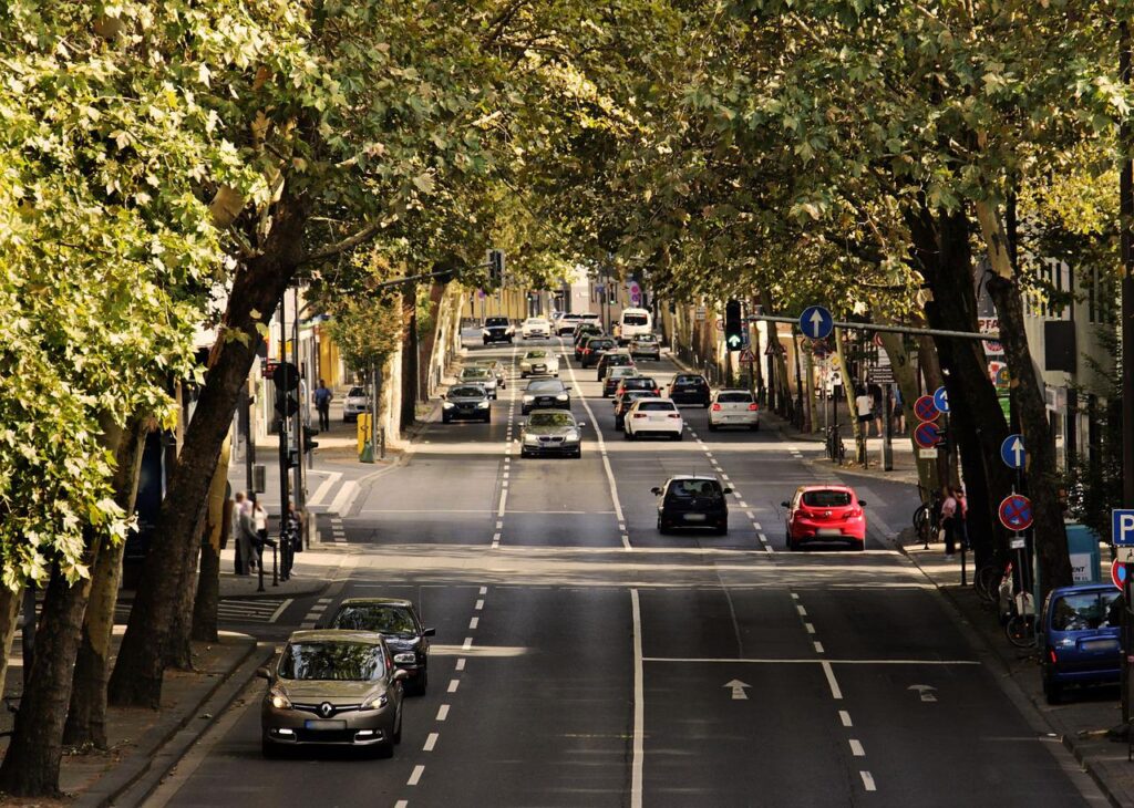 Imagem mostra uma avenida cheia de carros.