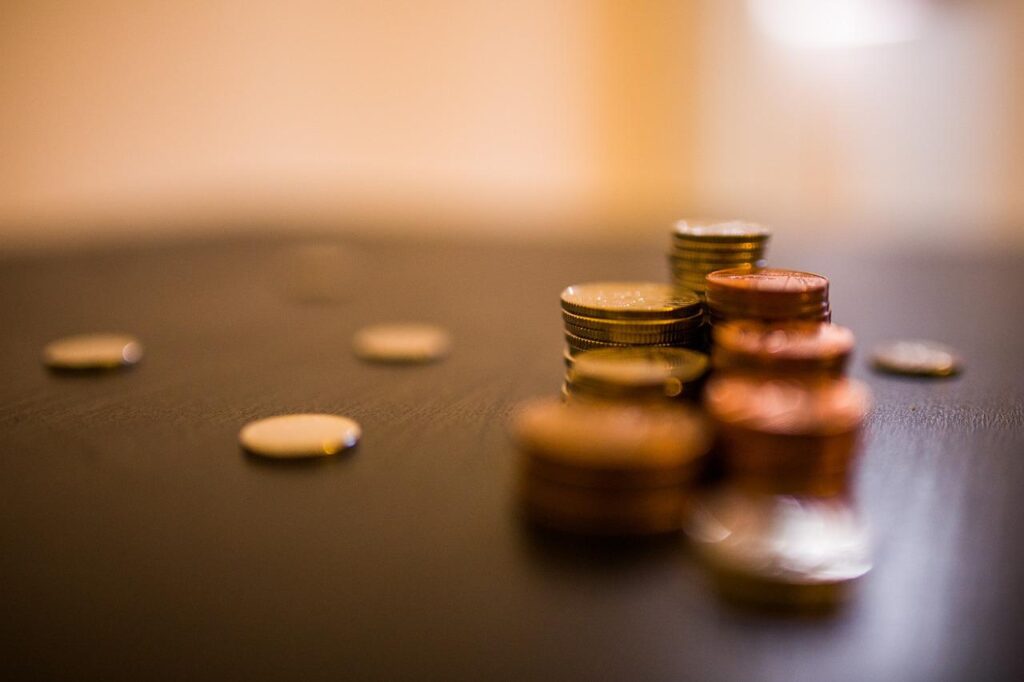 A imagem mostra algumas moedas sobre a mesa.