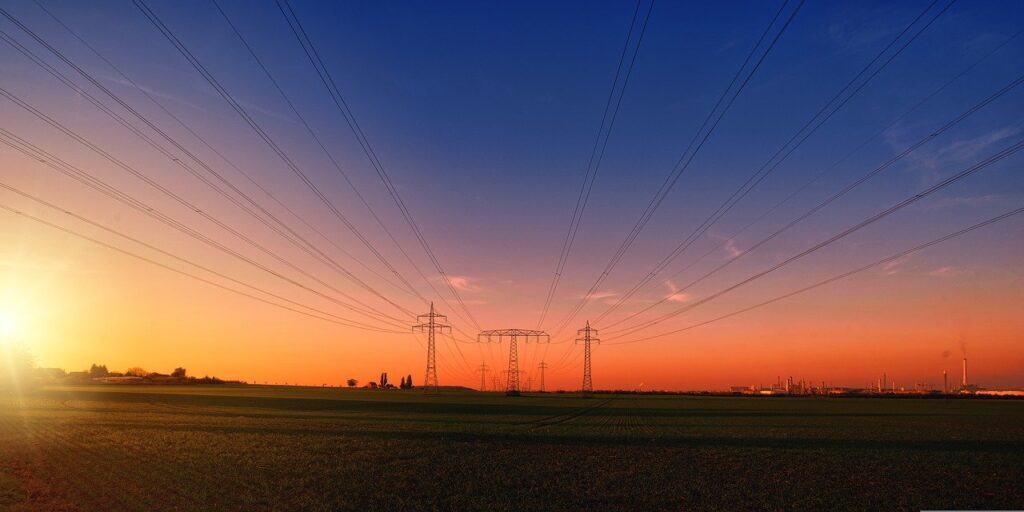 Imagem mostra torres de energia elétrica e cabos.