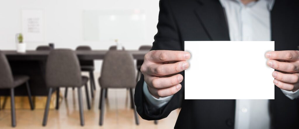 Imagem mostra um homem de terno com um papel em branco atrás de uma ideia.