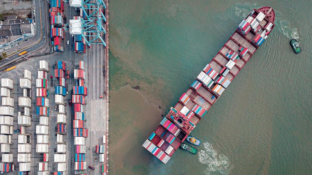 Imagem mostra um navio sendo manobrado em um porto.