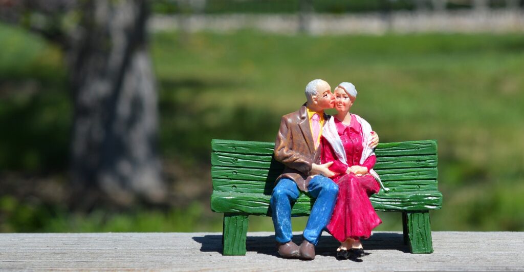 Imagem mostra dois bonecos que foram um casal sentado em um banco de praça.