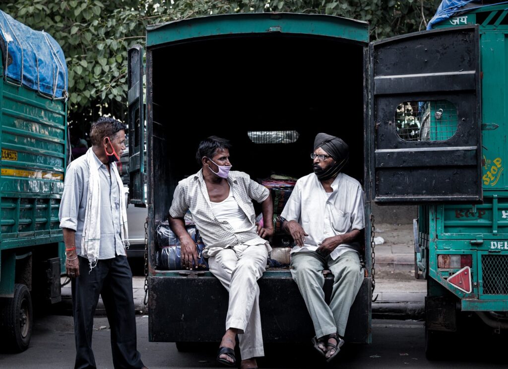 Imagem mostra três indianos conversando.