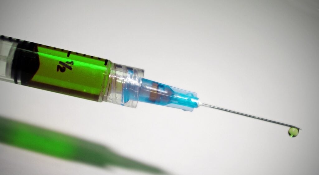 Imagem mostra uma seringa com medicamentos.