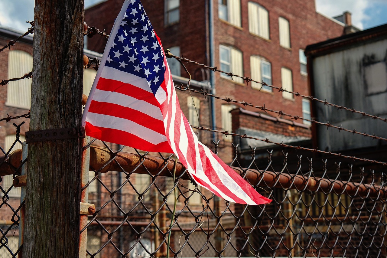 Imagem mostra uma bandeira pequena dos EUA em um post em rua de Nova York.
