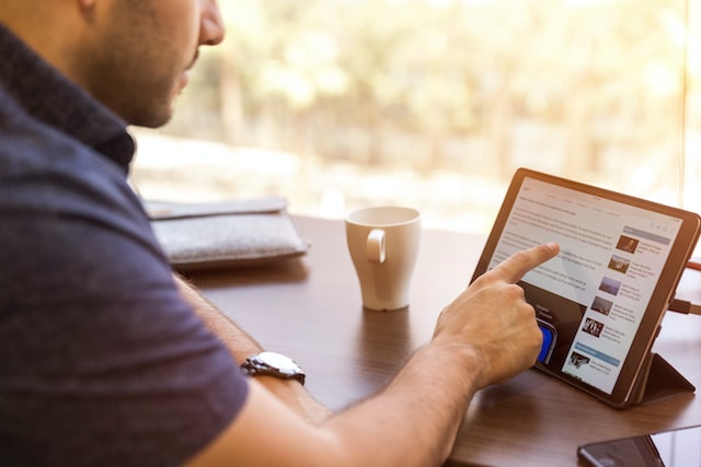Imagem mostra um homem lendo o noticiário no tablet.