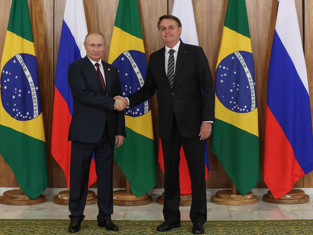 Putin, à esquerda, aperta a mão do então presidente Jair Bolsonaro