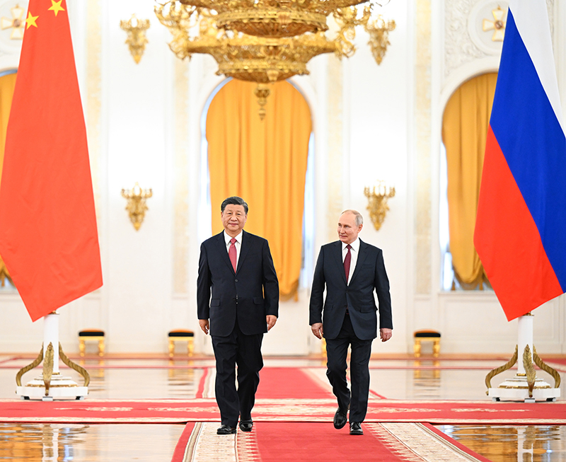 Xi jinping, à esquerda, um homem asiático, anda ao lado de Vladimir Putin, à direita, um homem causasiano