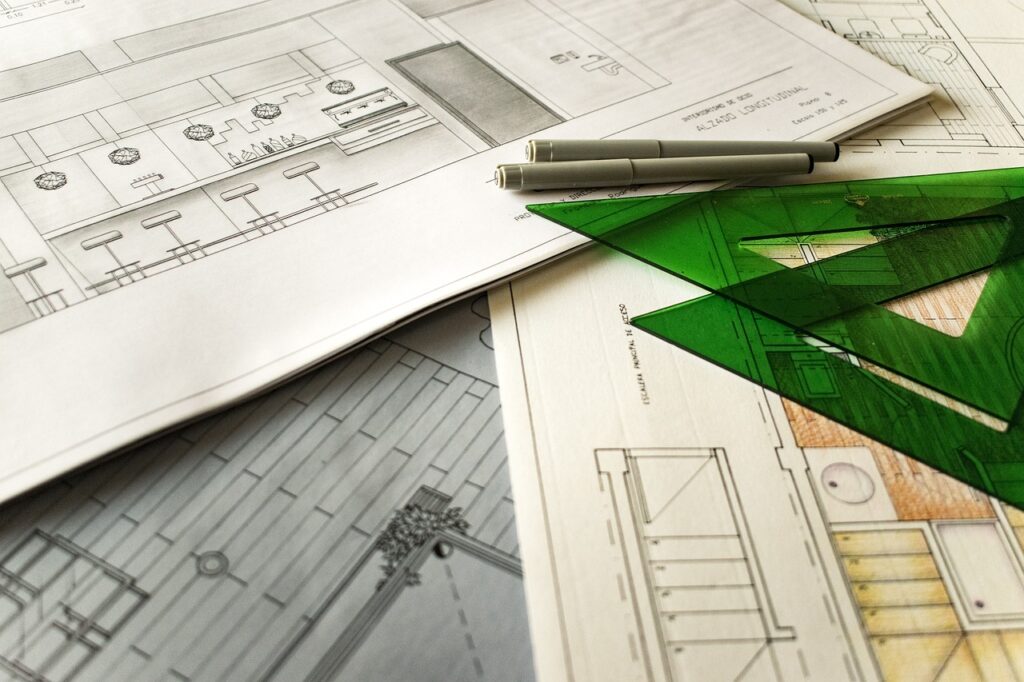 Imagem mostra um desenho técnico e uma ferramenta sobre a mesa.