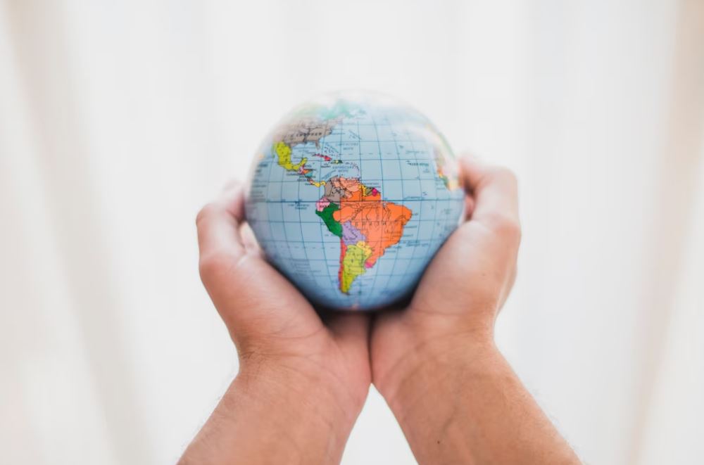 foto de mão segurando globo, onde se vê a América Latina: EQI Long Bias