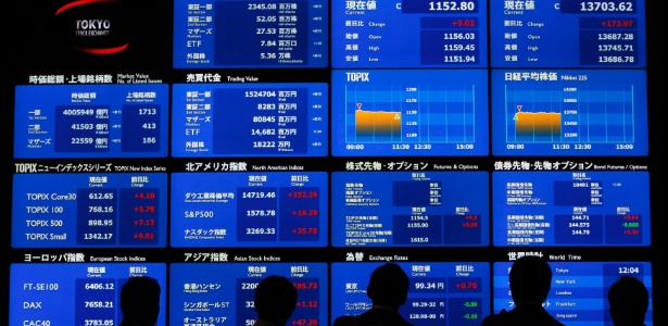 Imagem mostra pessoas observando a bolsa de valores do Japão.