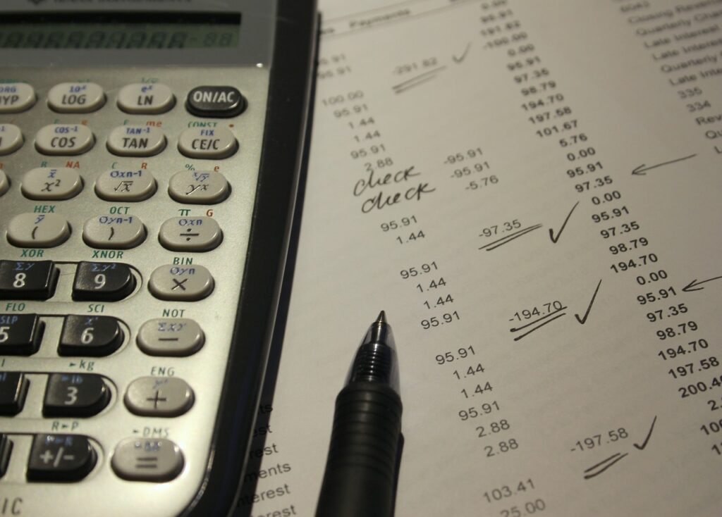 Imagem mostra uma calculadora sobre um documento de taxas e uma caneta.