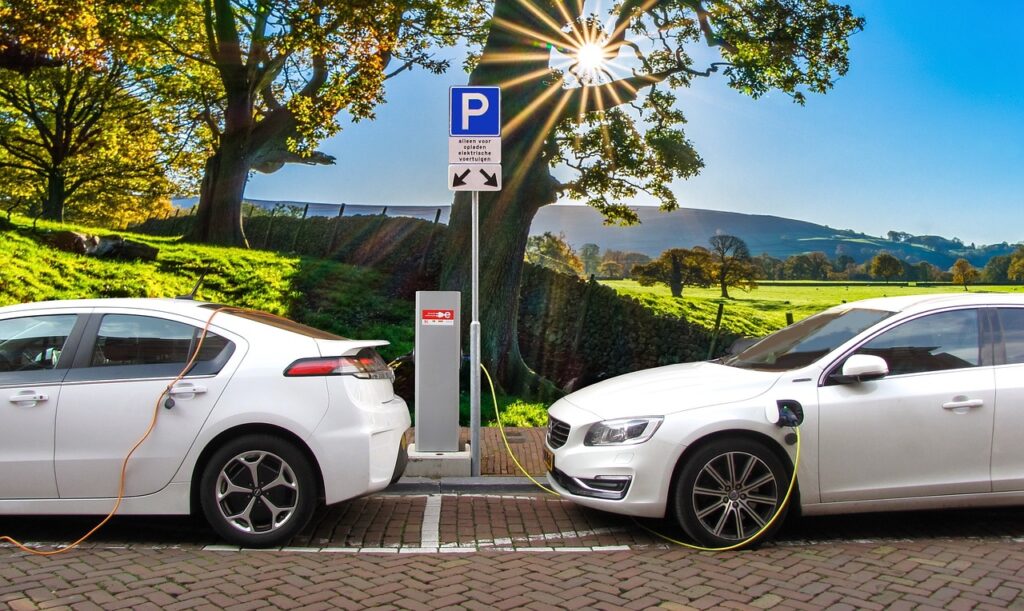 Imagem mostra dois carros elétricos sendo abastecidos.