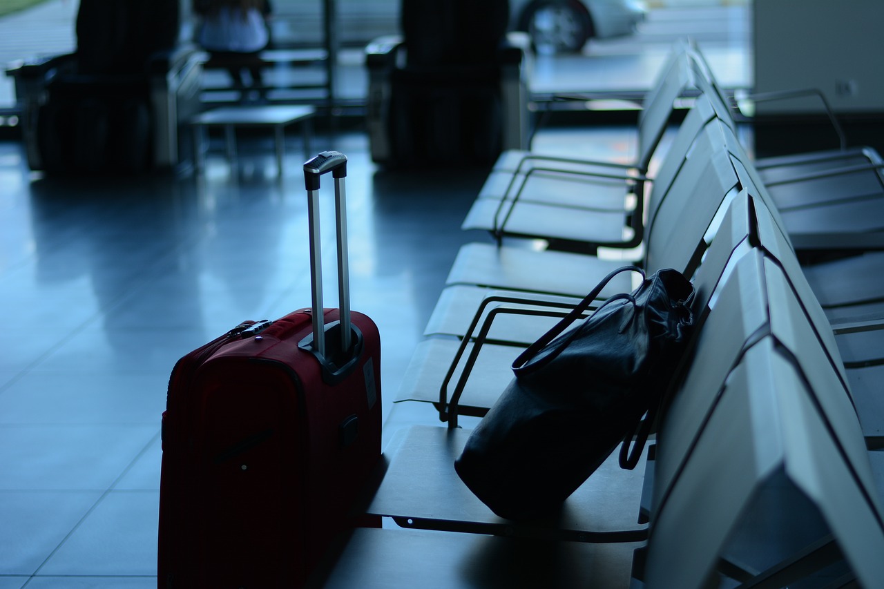 Imagem mostra umas malas em saguão de aeroporto.