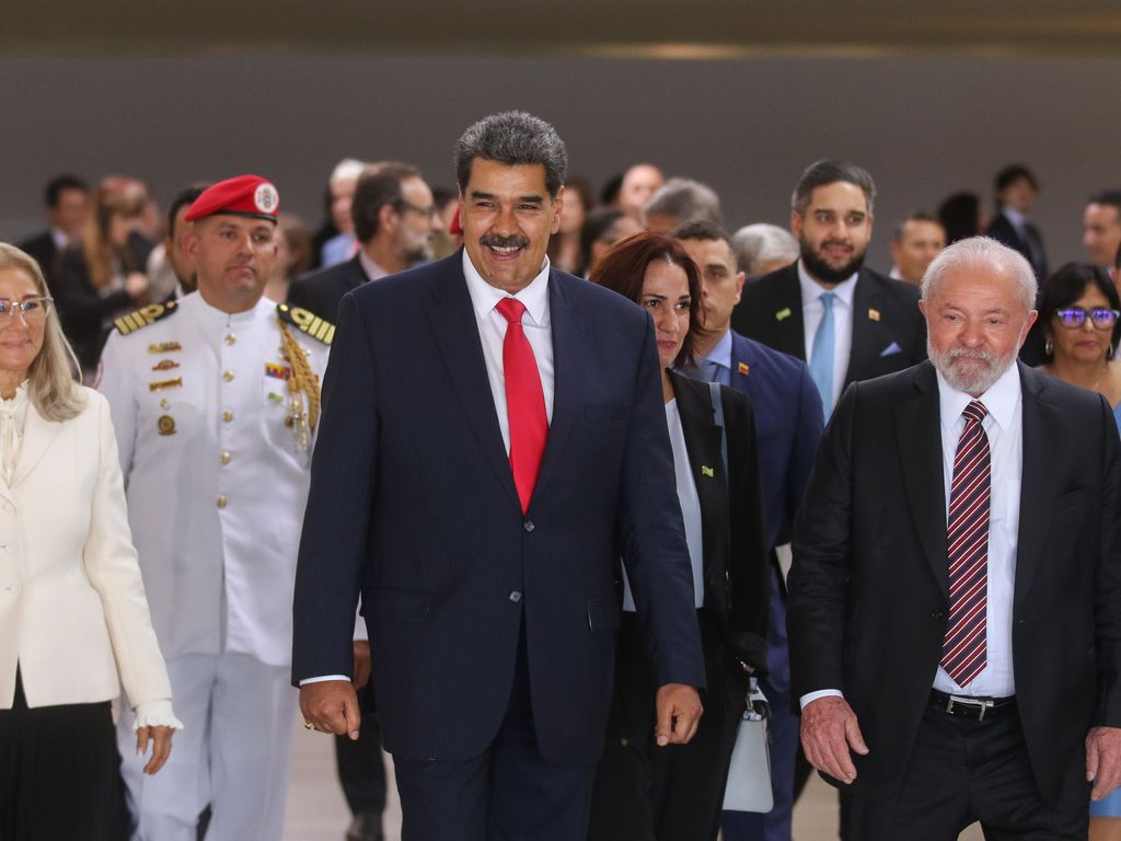 Imagem mostra o presidente da Venezuela e sua comitiva caminhando ao lado de Lula.