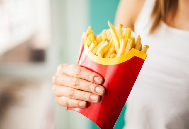 Pessoa segura porção de batatas fritas
