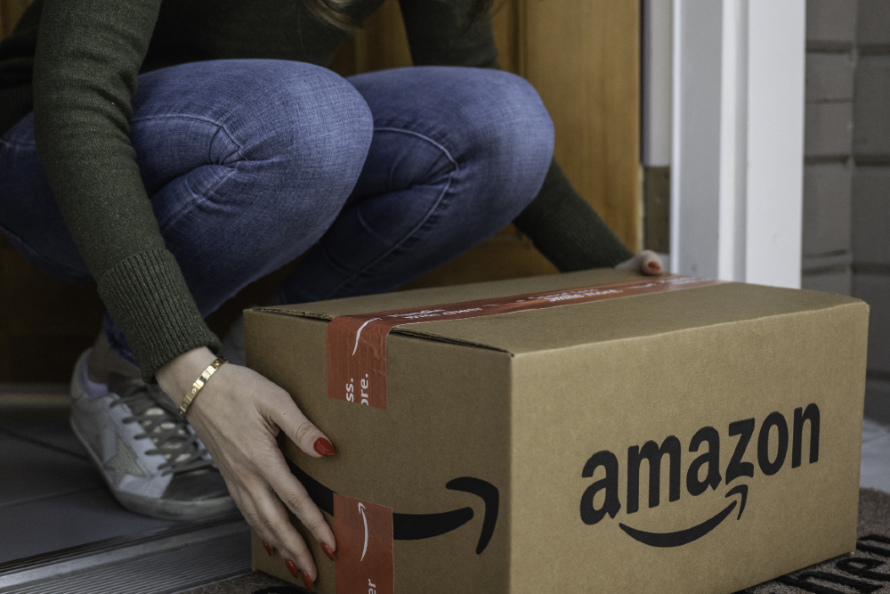 Foto de mulher pegando caixa da Amazon para matéria sobre balanço da empresa