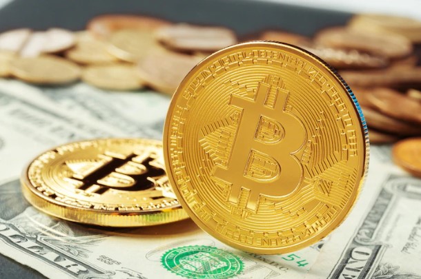 tributação de criptos e carteiras digitais: foto de bitcoin e notas de dólares