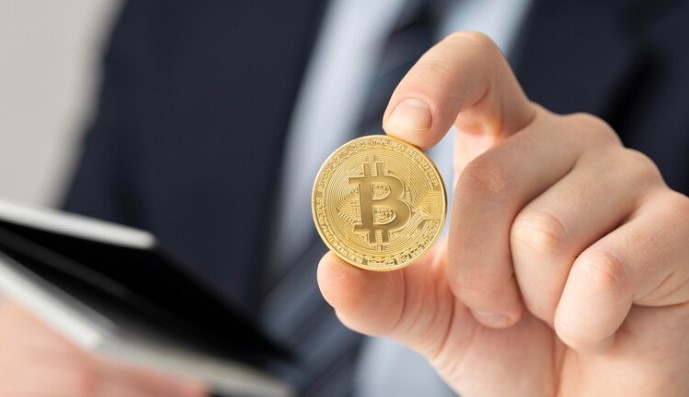 ETF spot de Bitcoin: foto de pessoa segurando moeda de Bitcoin