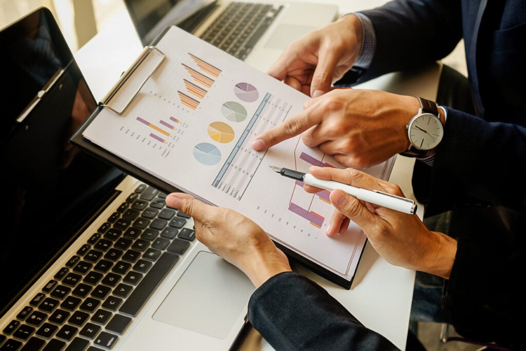 Taxa de Corretagem. Dois homens analisando gráficos.