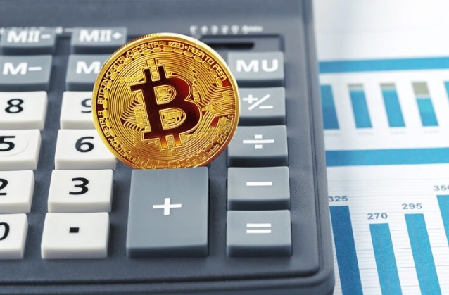 como declarar criptomoedas no imposto de renda: imagem de moeda de Bitcoin sobre calculadora