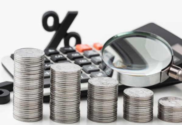 Tesouro IPCA + 6%: foto de lupa, pilhas de moedas e calculadora