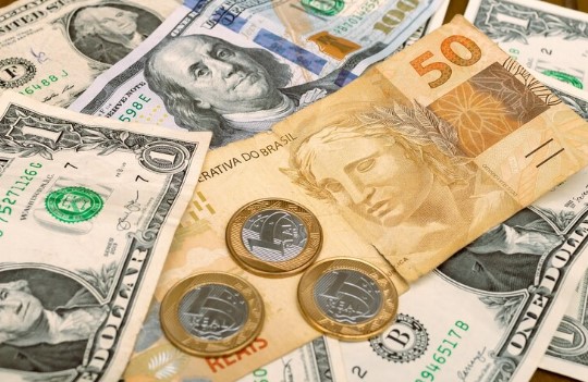 IPCA+ ou dólar+: imagem dólar e real, notas de dinheiro