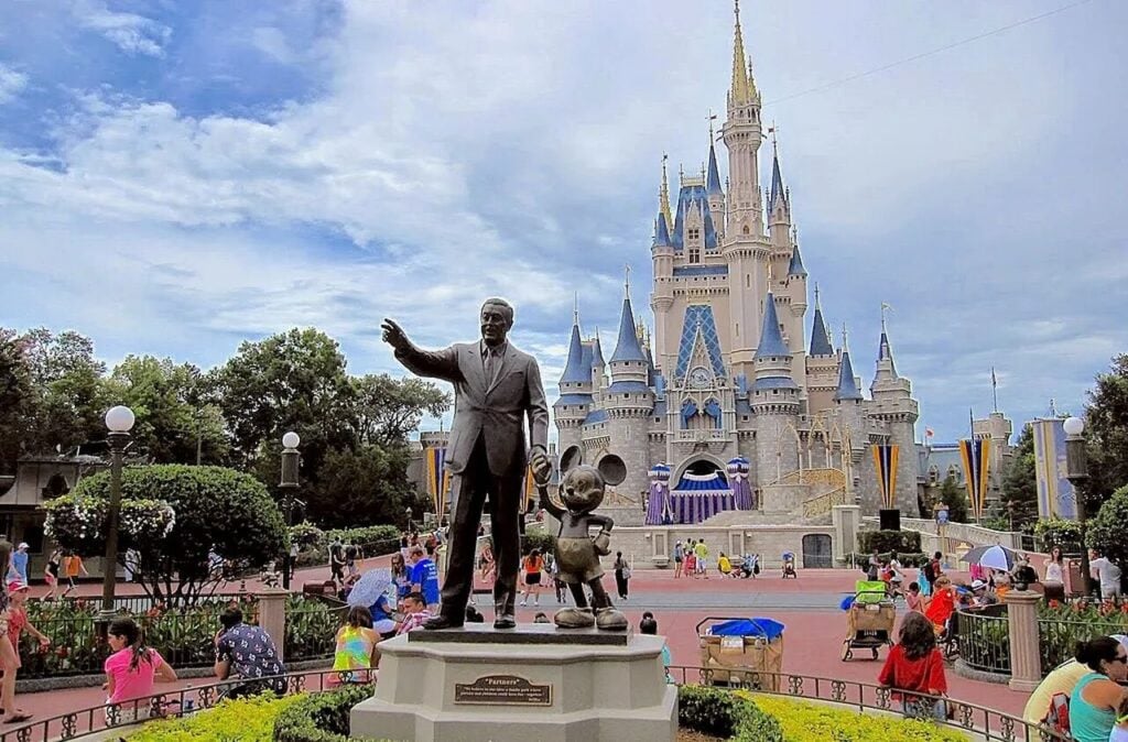 Estátua de Walt Disney com o Castelo da Cinderela ao fundo, no Magic Kingdom, primeiro parque do Walt Disney World Resort - Wikimedia Commons