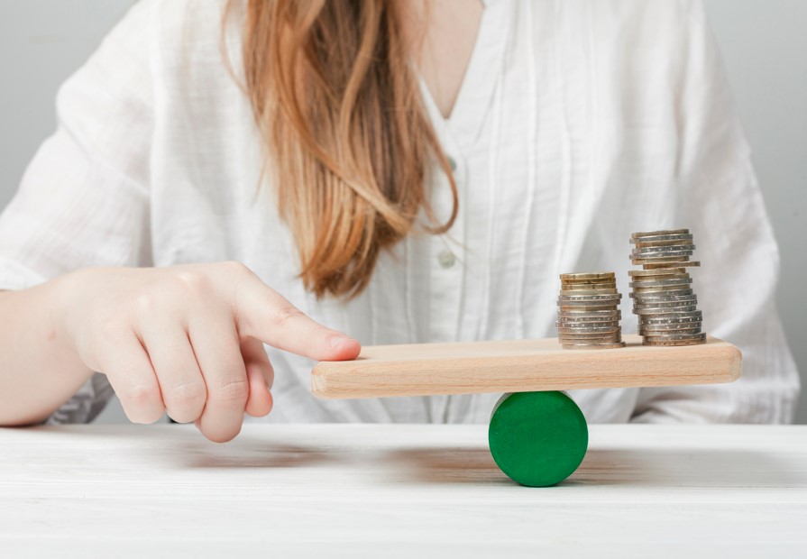 alocação de ativos: foto de mulher analisando moedas em balança