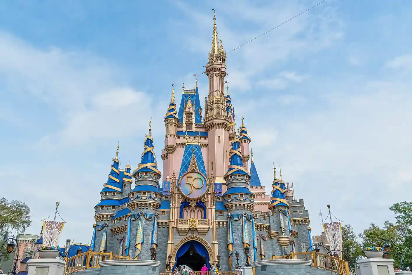 Castelo da Disney no Magic Kingdom, símbolo dos parques temáticos da Disney, sob céu azul claro.