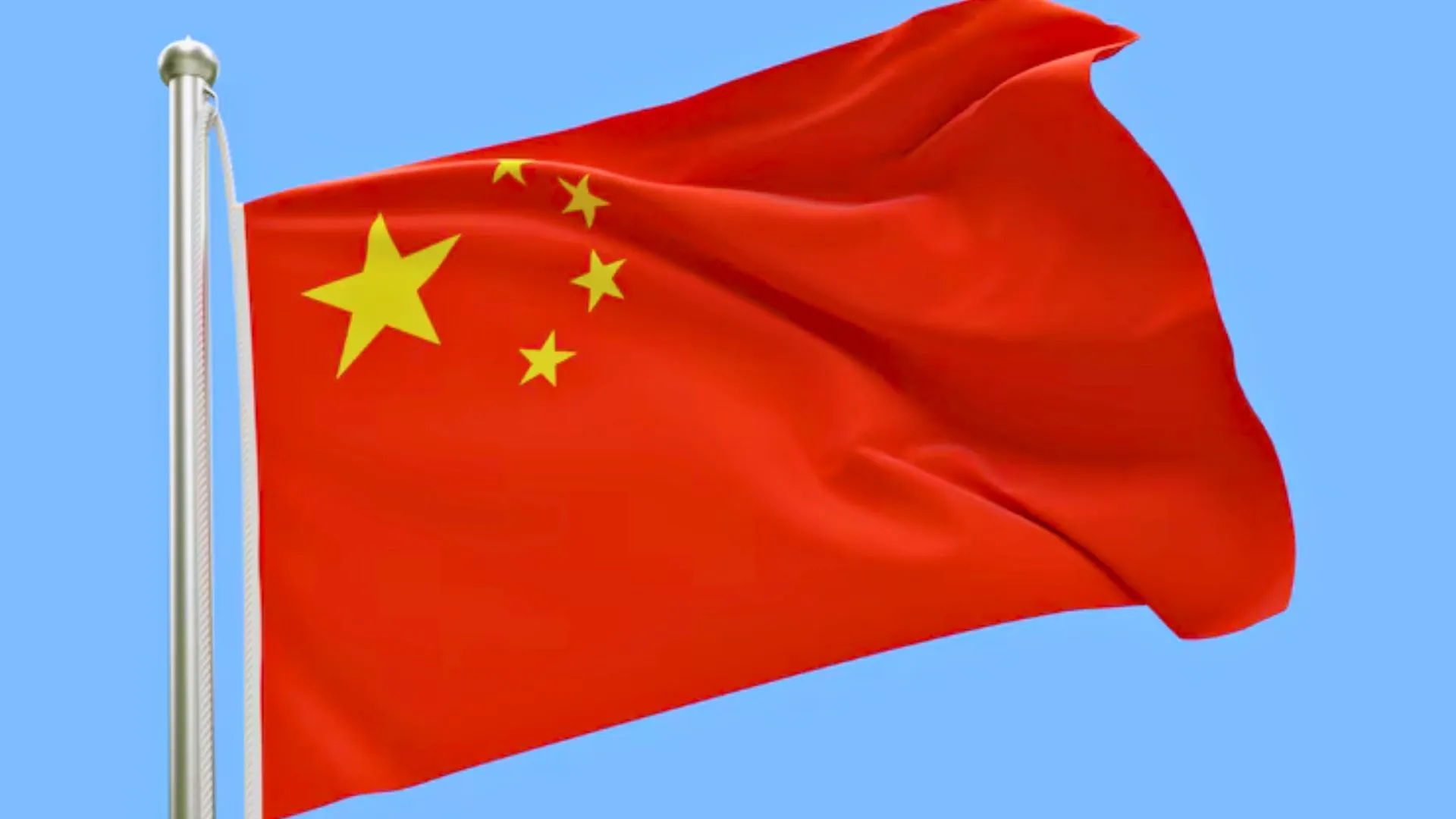 Bandeira da China tremulando ao vento com fundo azul.