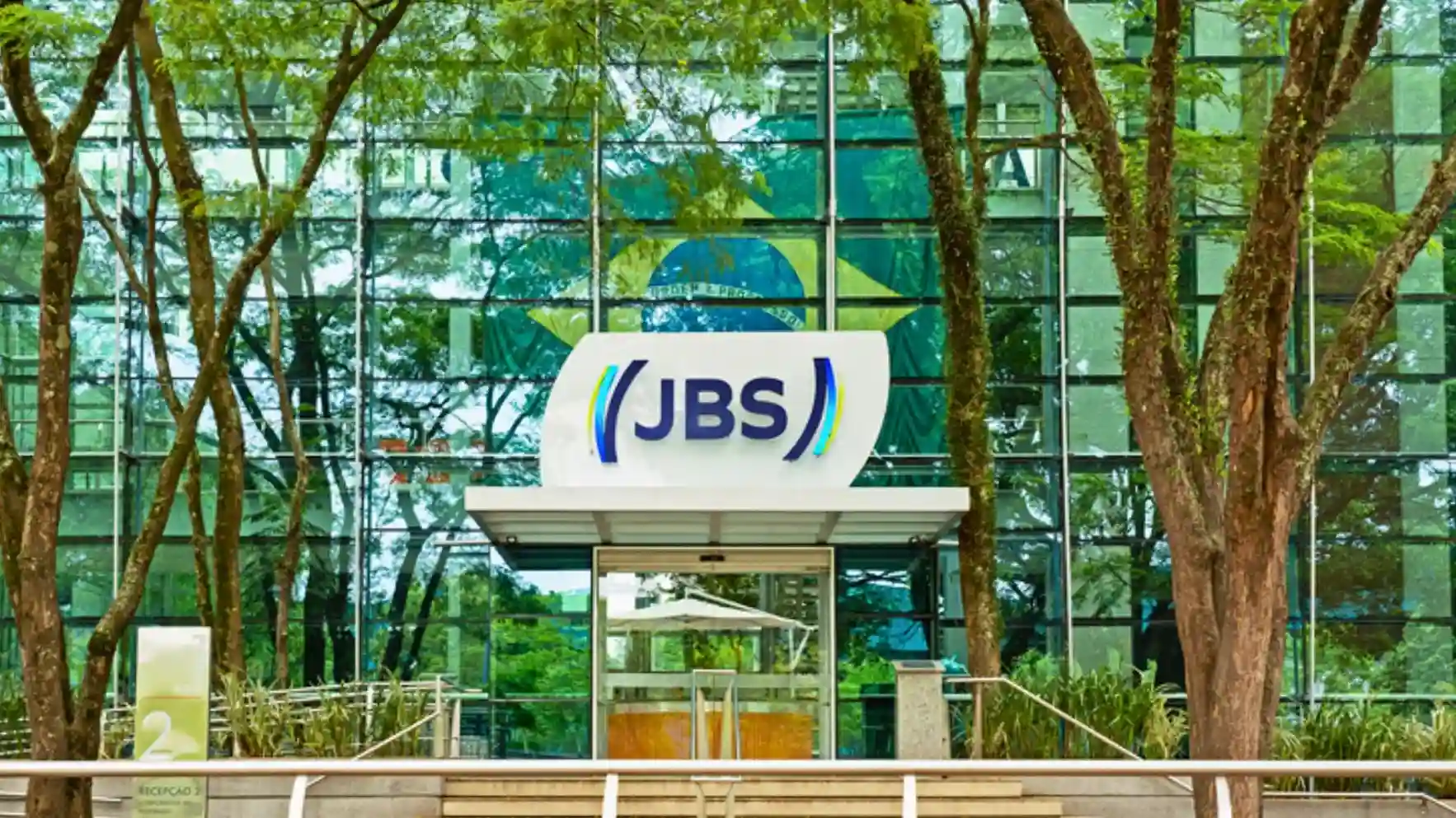 Fachada da sede da JBS com o logo da empresa em destaque, simbolizando a dupla listagem.