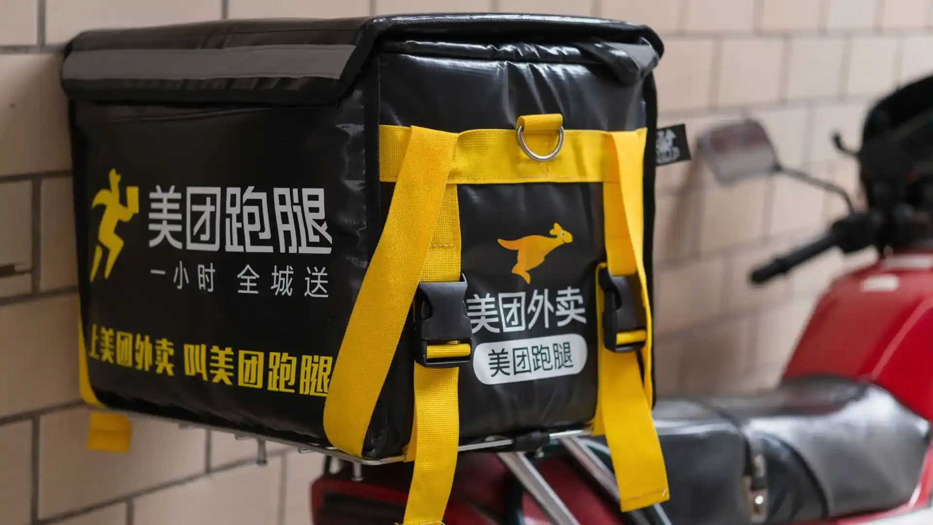 Entregador da Keeta com mochila de delivery em moto, representando a operação da Meituan no Brasil