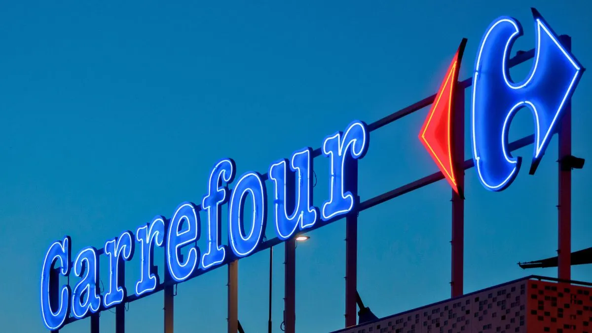 Logotipo iluminado do Carrefour, simbolizando a tributação de dividendos BDR.