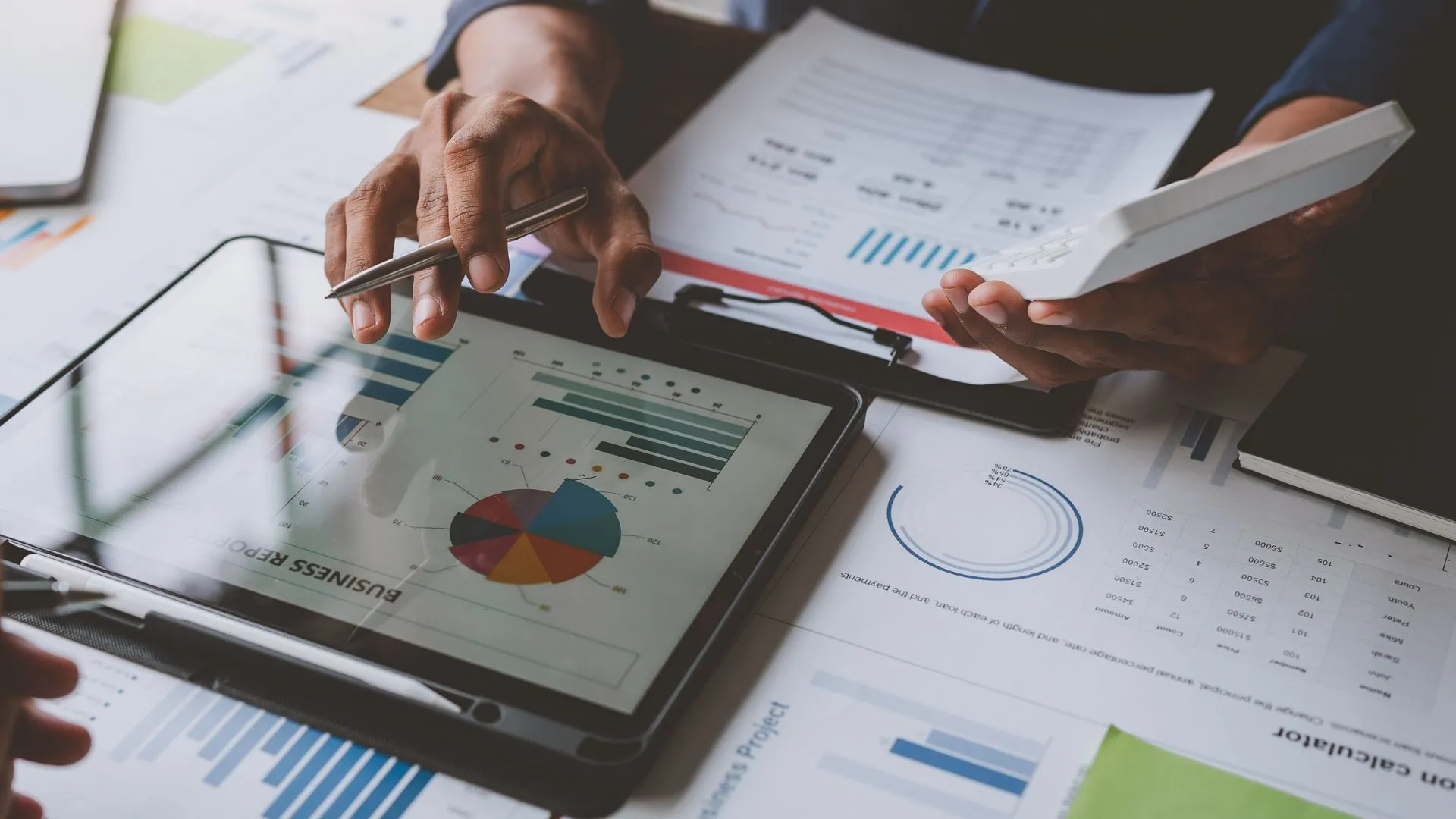 Pessoas analisando gráficos de fundos de investimento em tablet