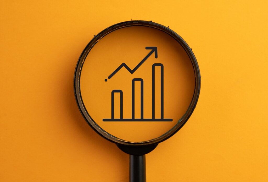 foto de lupa analisando gráfico de investimento. Foto: Adobe Stock Photos