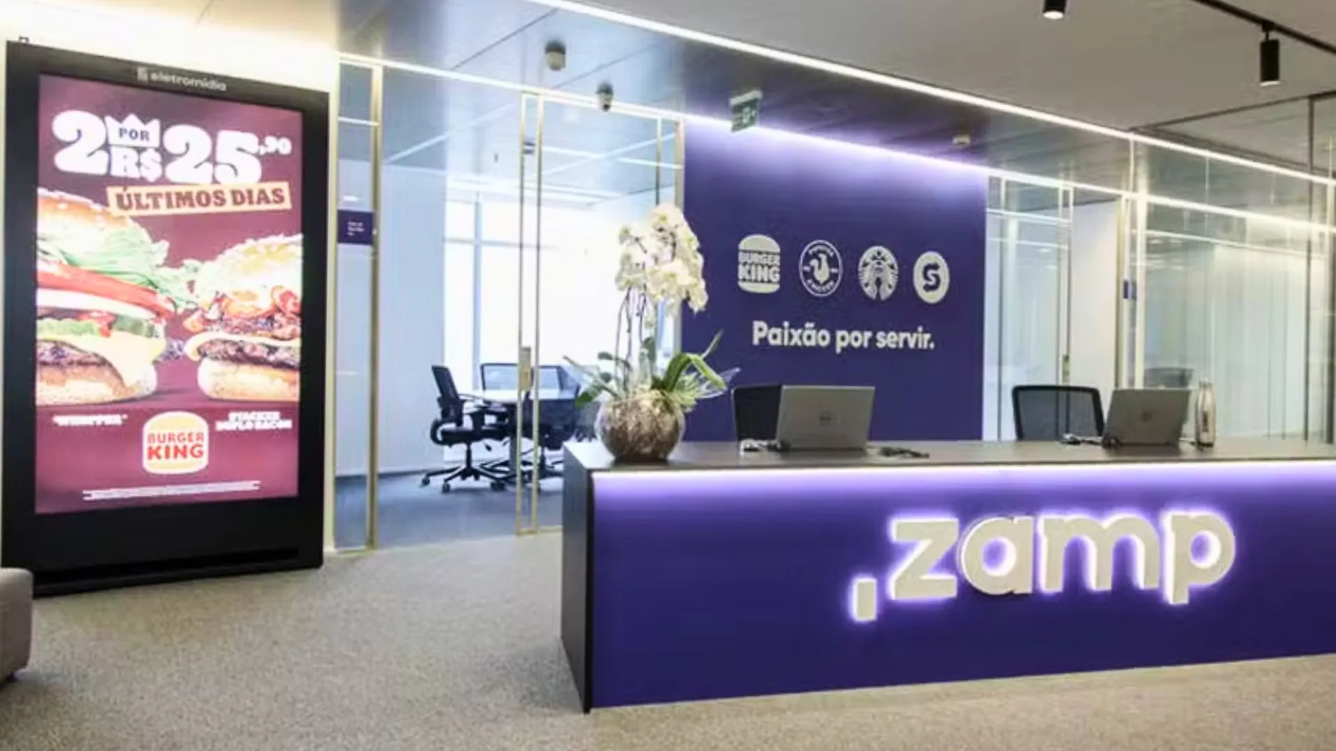 Interior da sede da Zamp com logo em destaque, relacionado à OPA