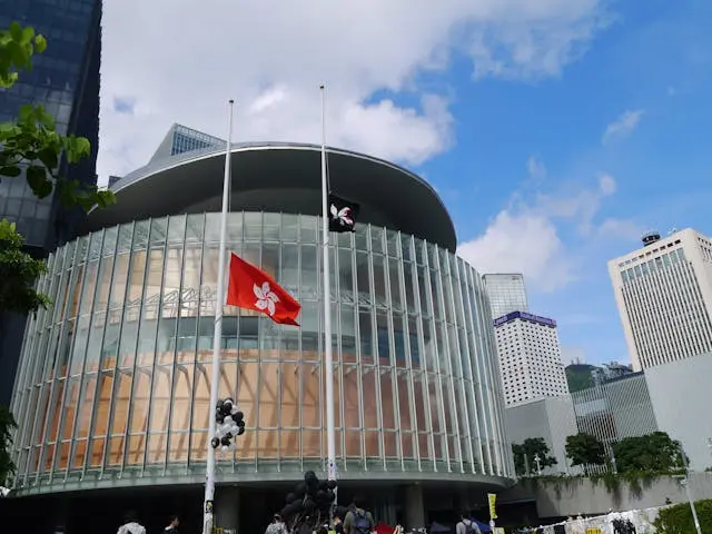 Bandeira de Hong Kong tremula diante de edifício