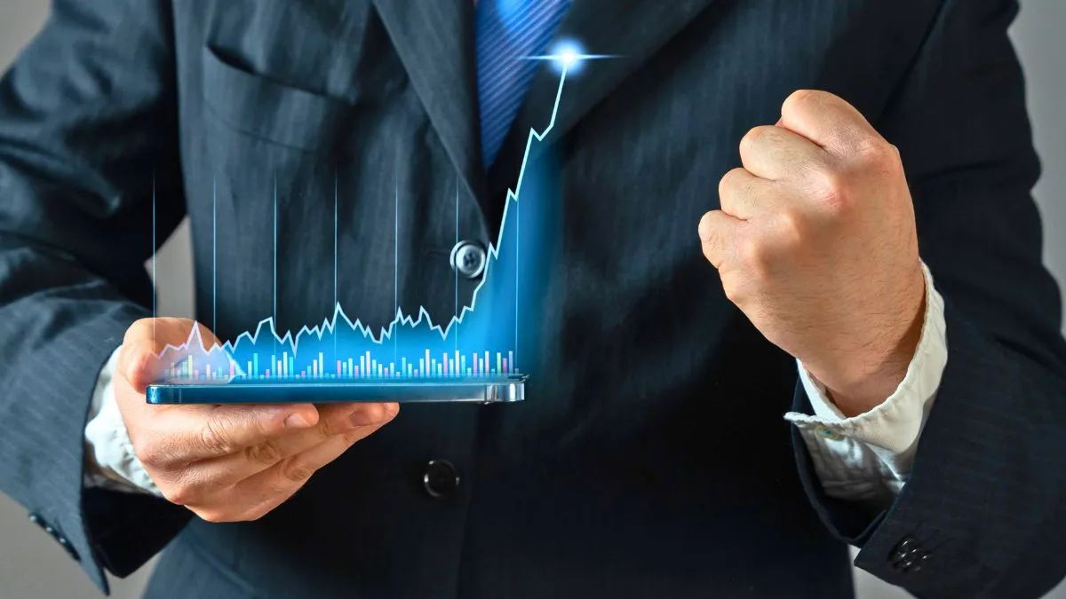 Homem de terno segurando gráfico financeiro em ascensão, representando o investimento em Small Caps