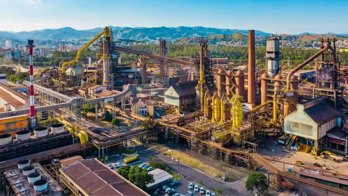 Vista aérea de uma planta industrial da Usiminas, representando o balanço da empresa.