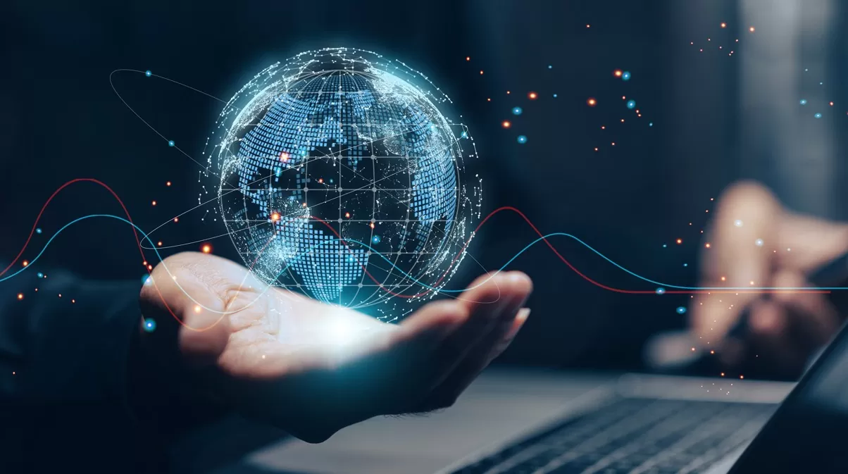 Melhores oportunidades de investimento no exterior: imagem de investidor ao computador, segurando um globo terrestre
