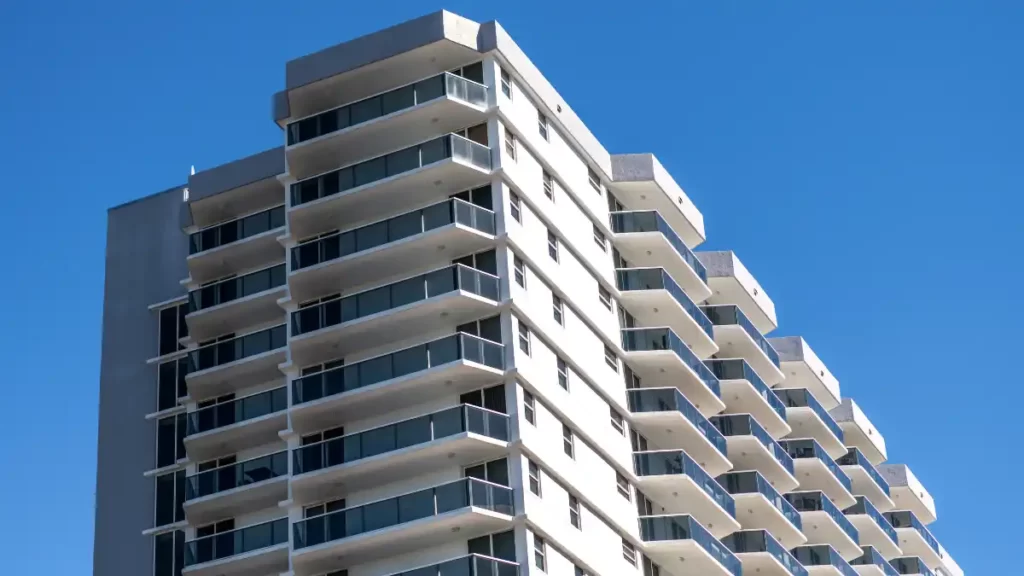 Prédio residencial moderno e de alto padrão, com múltiplas varandas e fachada de vidro, ilustrando a classe de ativos Private Real Estate.